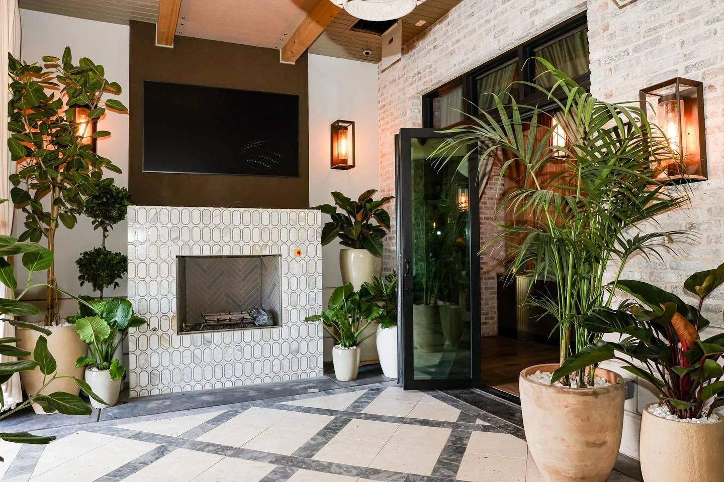 Planted hotel lounge with fireplace and palms